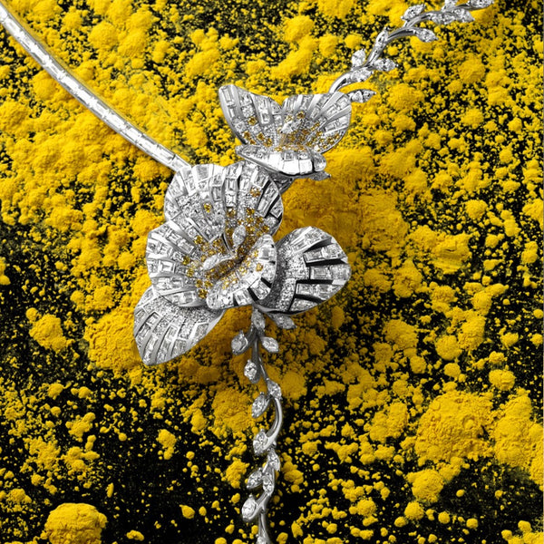Silver necklace with floral design on yellow and black background